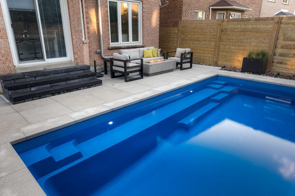Complete Toronto Backyard Landscaping Project with Concrete Pool Installation, Outdoor Fireplace, Interlocking Patio & Privacy Fence