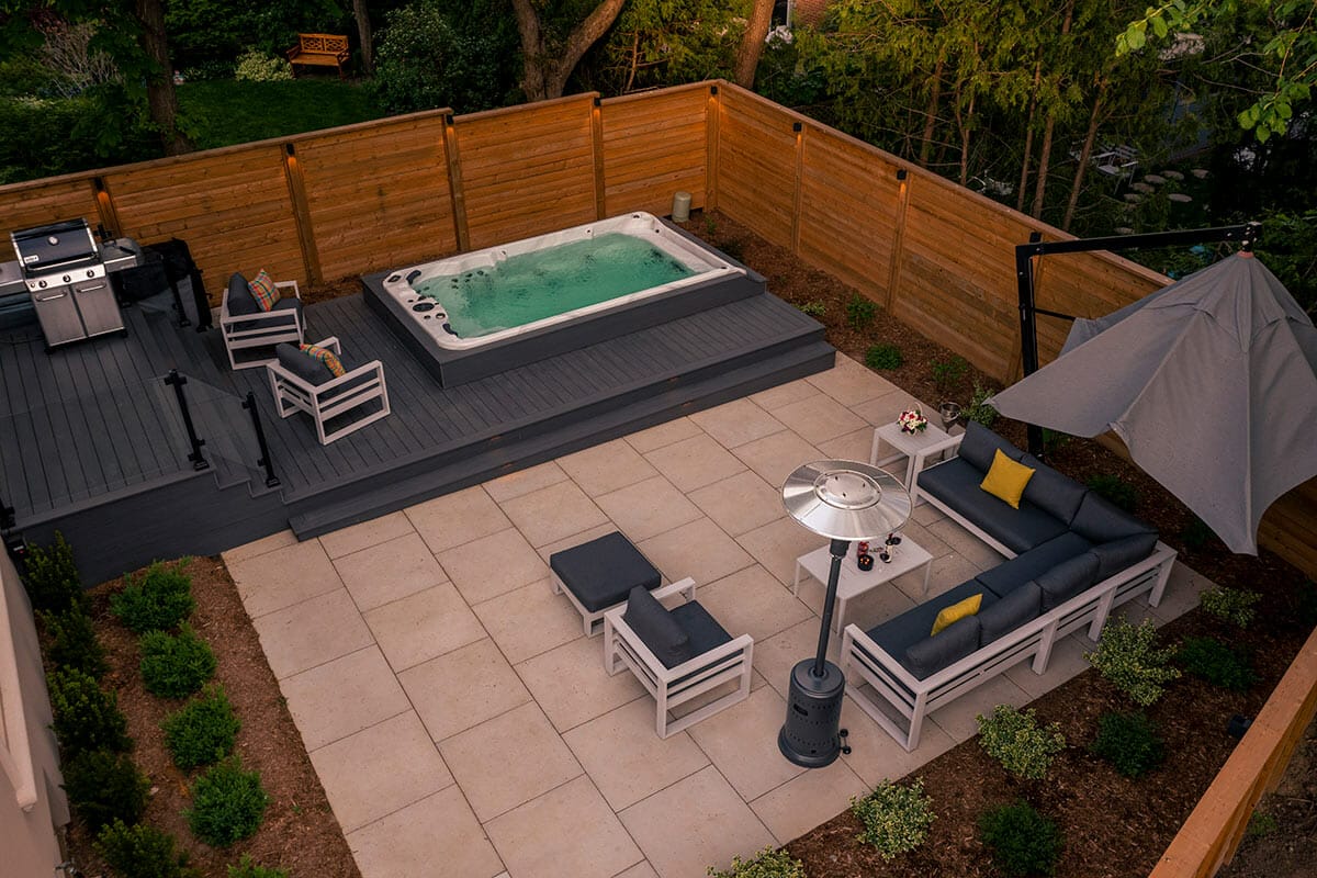 Outdoor construction Project; Featuring Interlocking, Spa Pool Installation, Fence Build, PVC Decking, Patio Design, with Glass and Aluminum Railings by M.E. Contracting