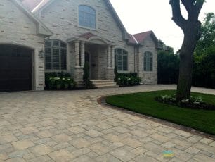 M.E. Contracting's completed project of a heated driveway covered by interlocking stone design. Also is the landscaping projects with the yard and flower beds.