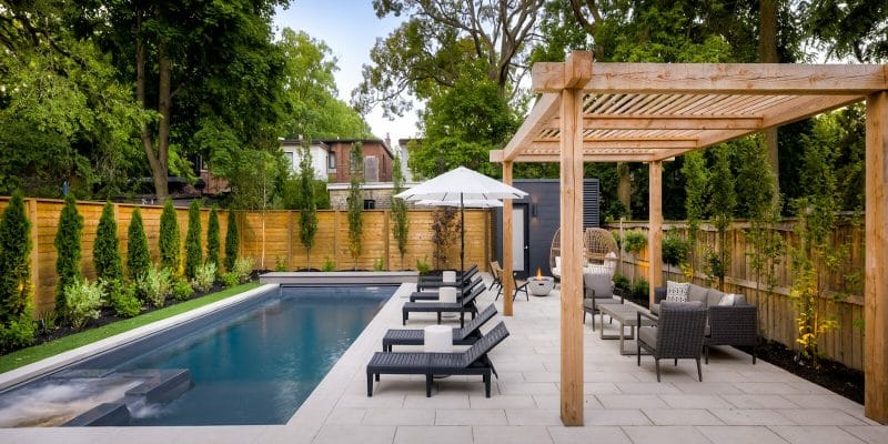 Modern Backyard Landscape Design and construction featuring Stone Interlocking, Pergola, Fiberglass Pool construction with Swim Spa