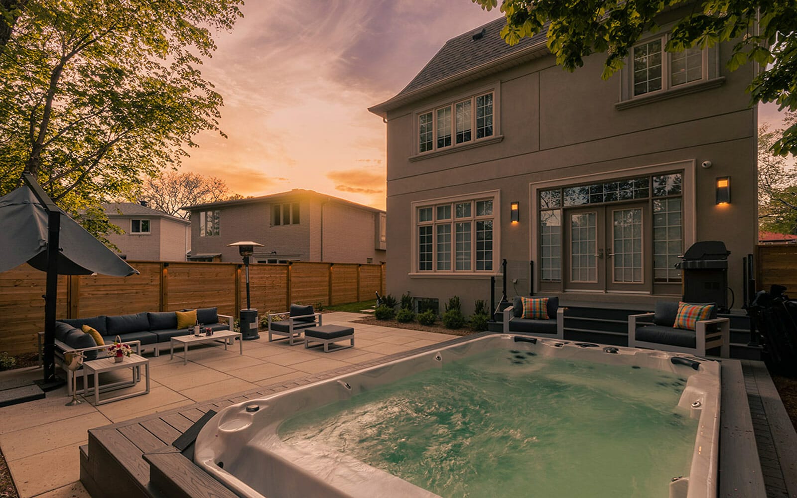 Premium Toronto Landscaping Project; Featuring Swim Spa Installation, PVC Deck with Glass Railings and Outdoor Lighting Features, Patio Stone Interlocking, and Privacy Fence Build by M.E. Contracting.