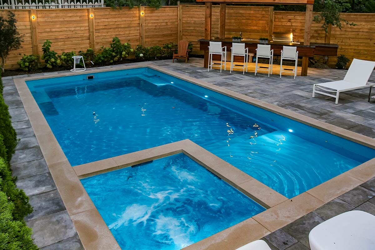 Total Landscape Design & Fiberglass Pool Installation Project; Featuring Privacy Fence, Pool Deck Interlocking, Woodworking Pergola & Outdoor Kitchen by Toronto Landscaping Company.
