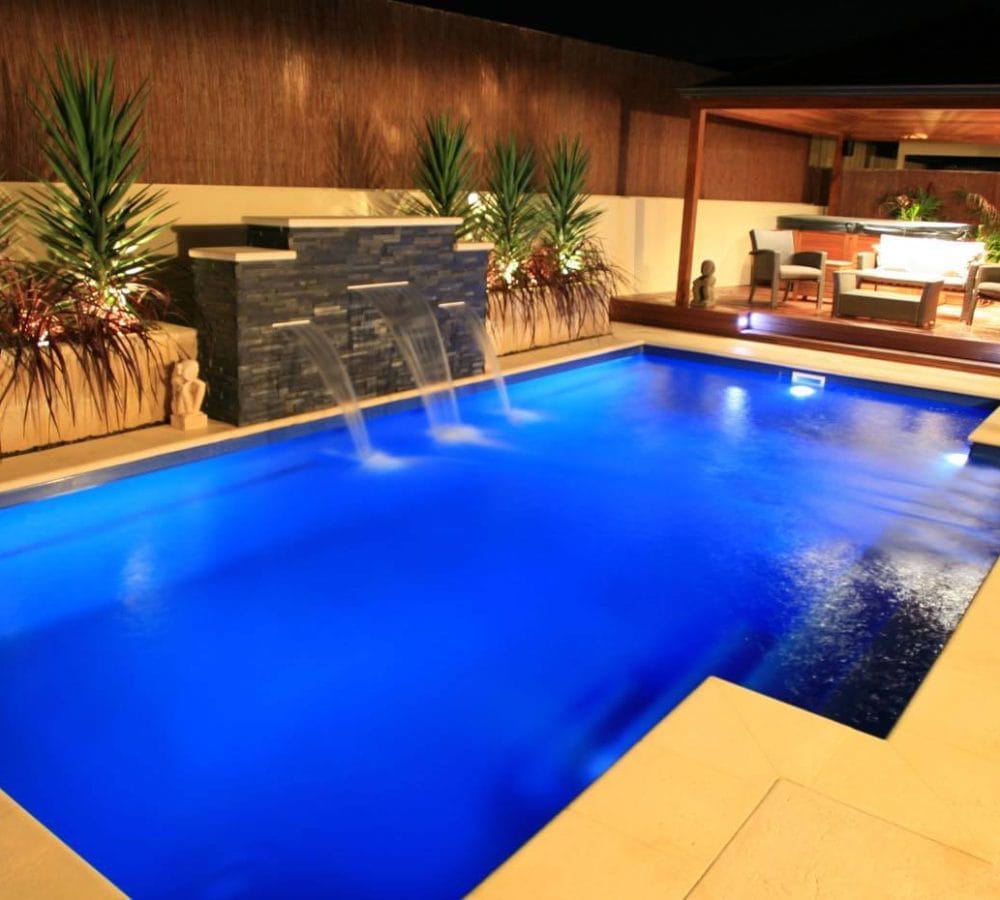 Elegance design fiberglass pool with water feature and coping by M.E. contracting pool company