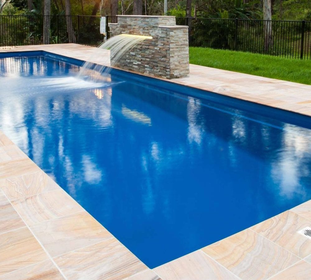 Elegance style fiberglass pool with coping and water feature installed by M.E. contracting pool company