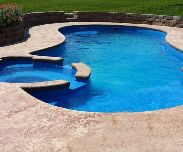 The Allure Fiberglass pool installed with side spa and coping