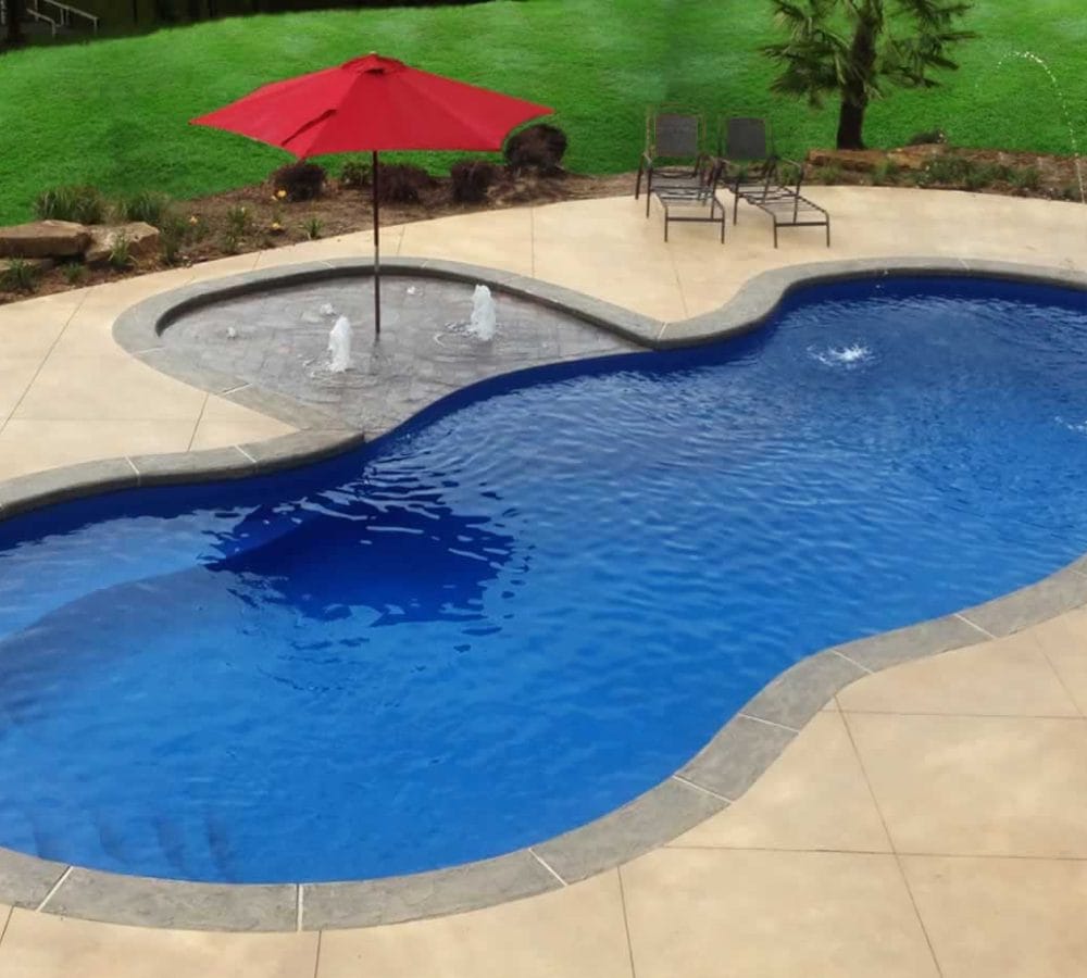 Mediterranean Fiberglass Pool with water feature and coping by M.E. contracting pool company